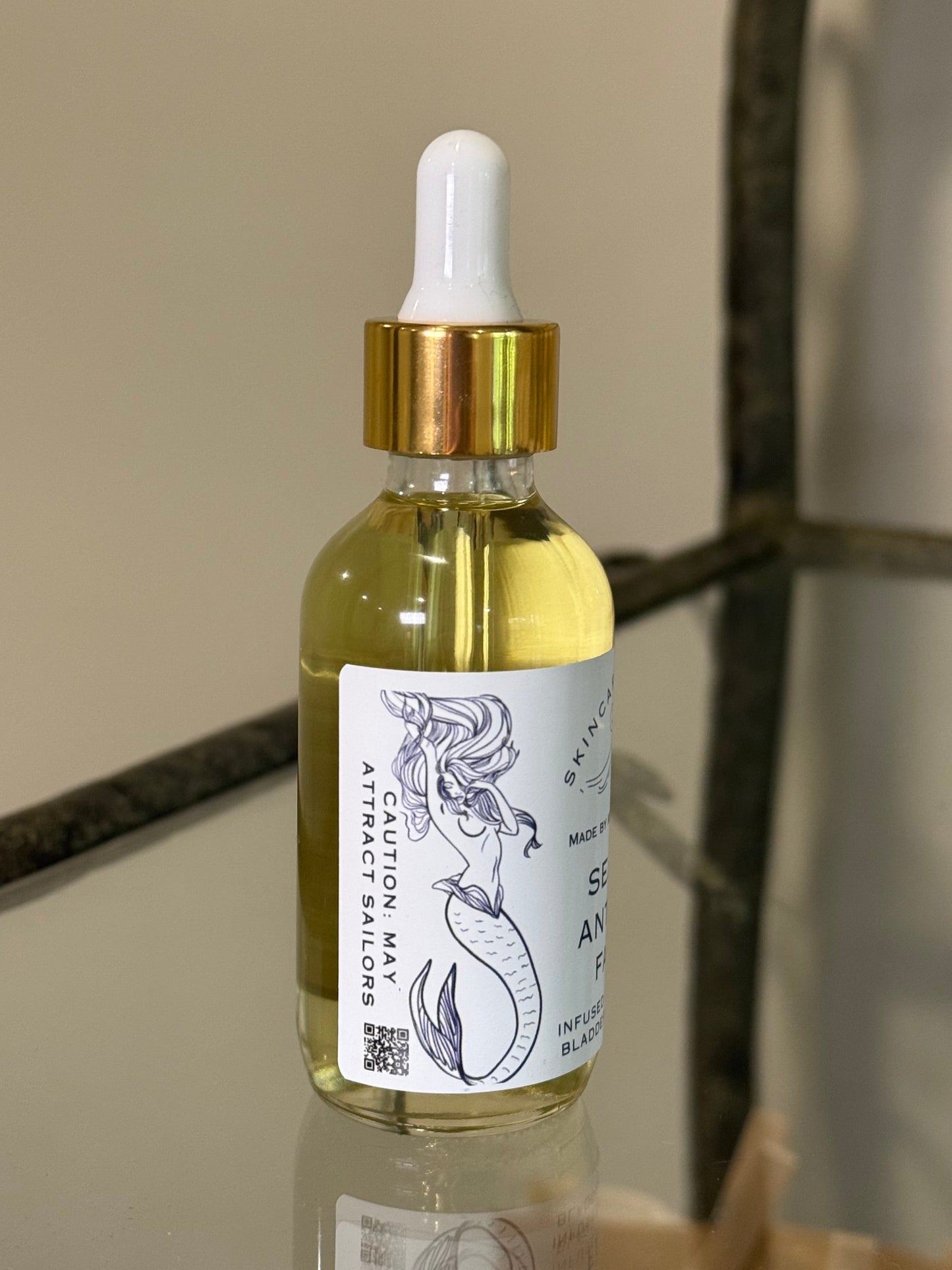 Bottle with dropper and label showing a mermaid