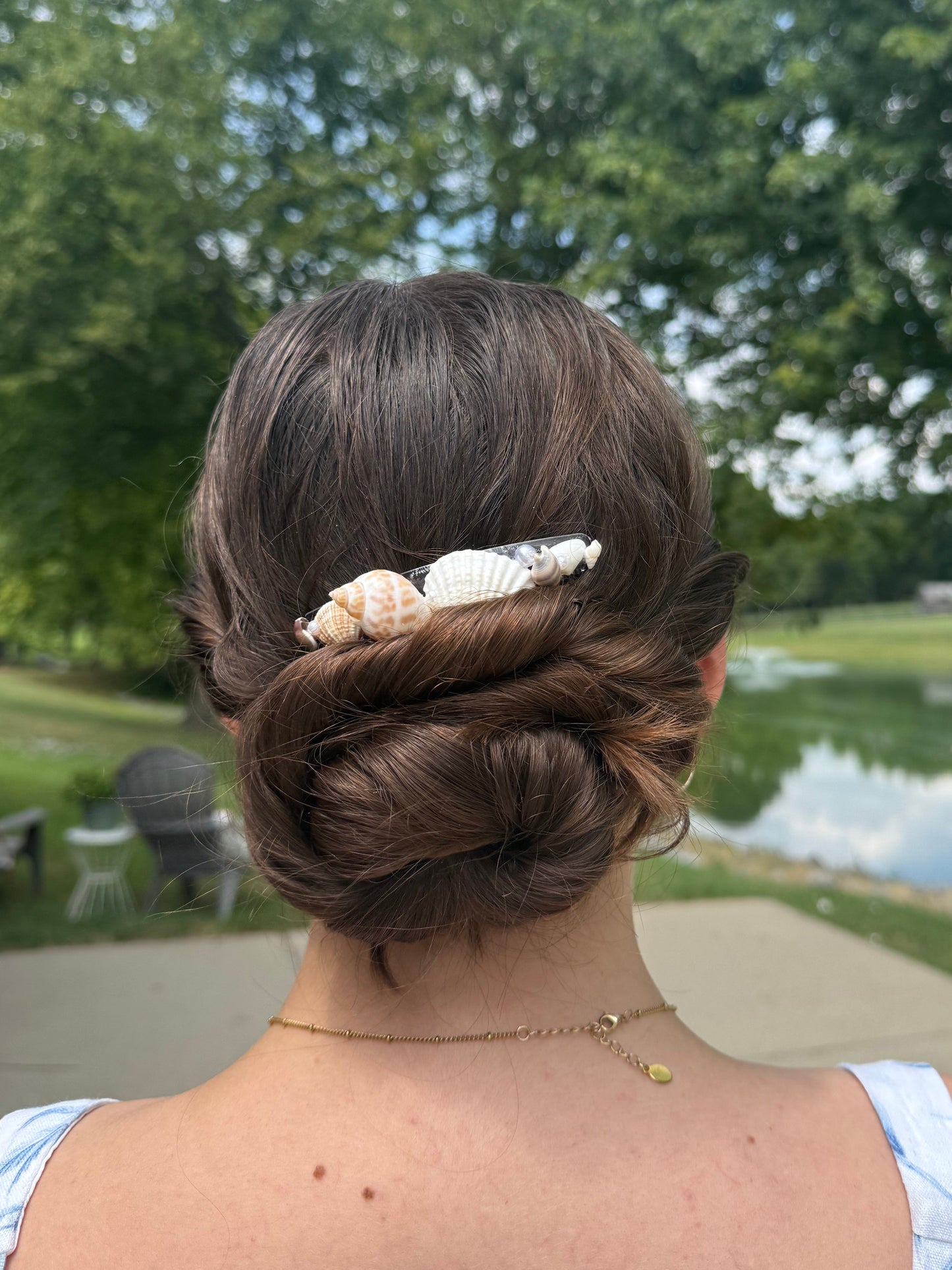 Person with a seashell hair comb outdoors
