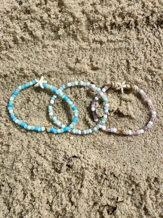 Three beaded bracelets on sand