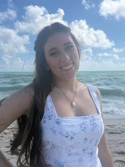 woman wearing a seashell necklace on a beach