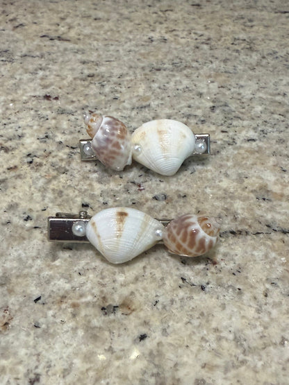 Shell-shaped hair clips on a textured surface