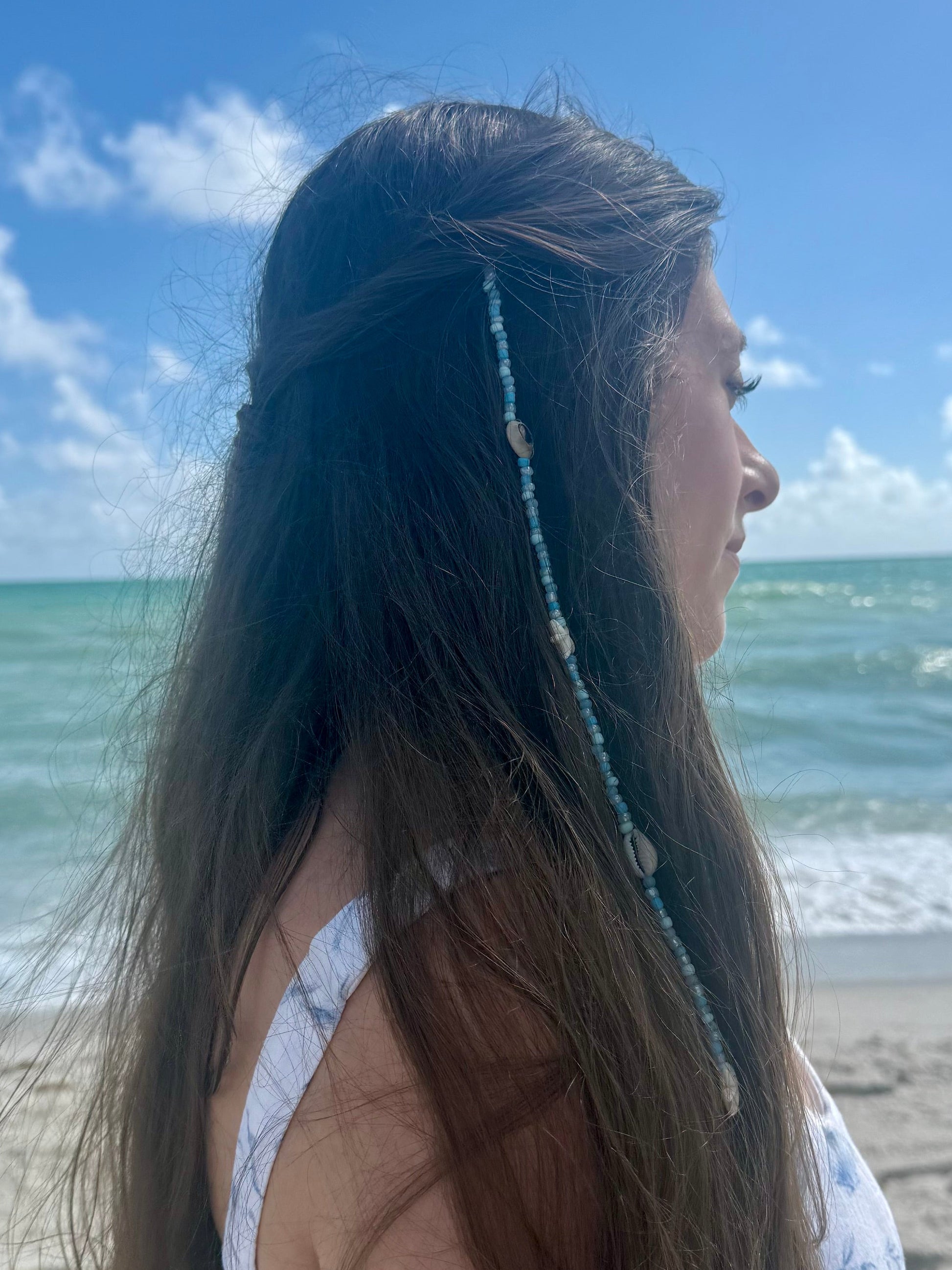 beaded seashell hair extension clip in woman's hair with beach background