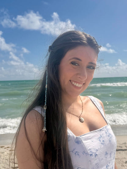 beaded hair extension clip in womans hair standing on a beach