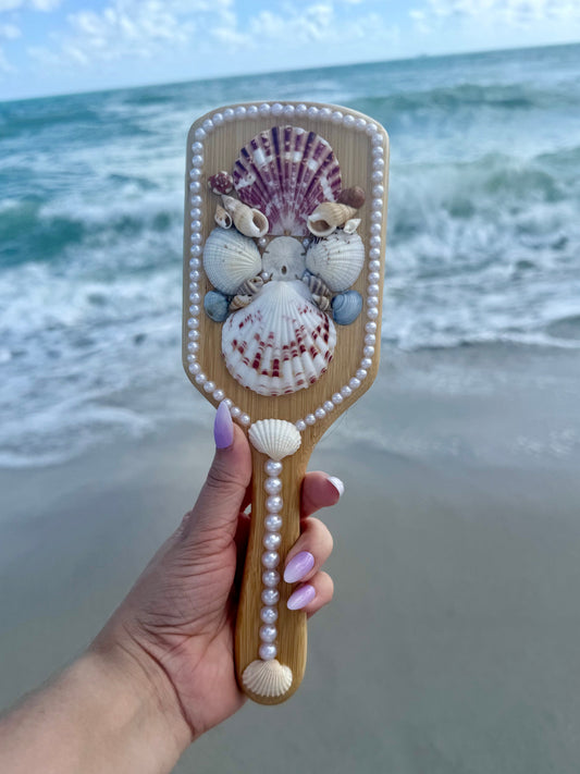 hand holding a mermaid seashell hairbrush