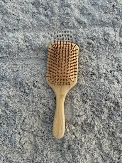 Bamboo hairbrush on a sandy beach background