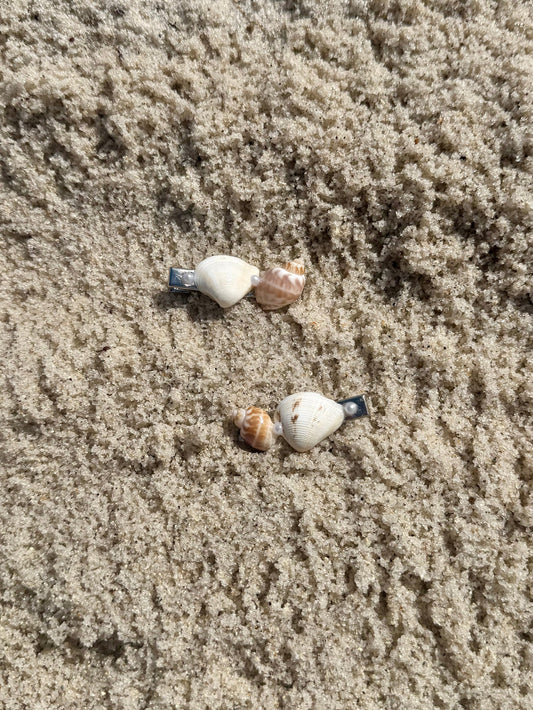 2 seashell hair clips on the sand