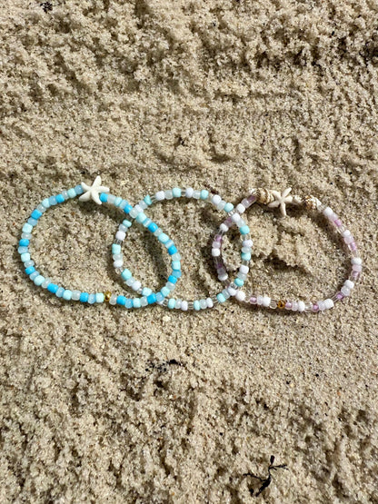 Three beaded bracelets on sand