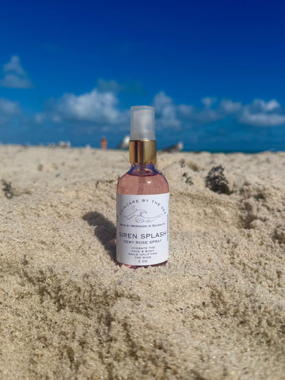 Siren Splash makeup setting spray on a beach with sand ocean and sky background