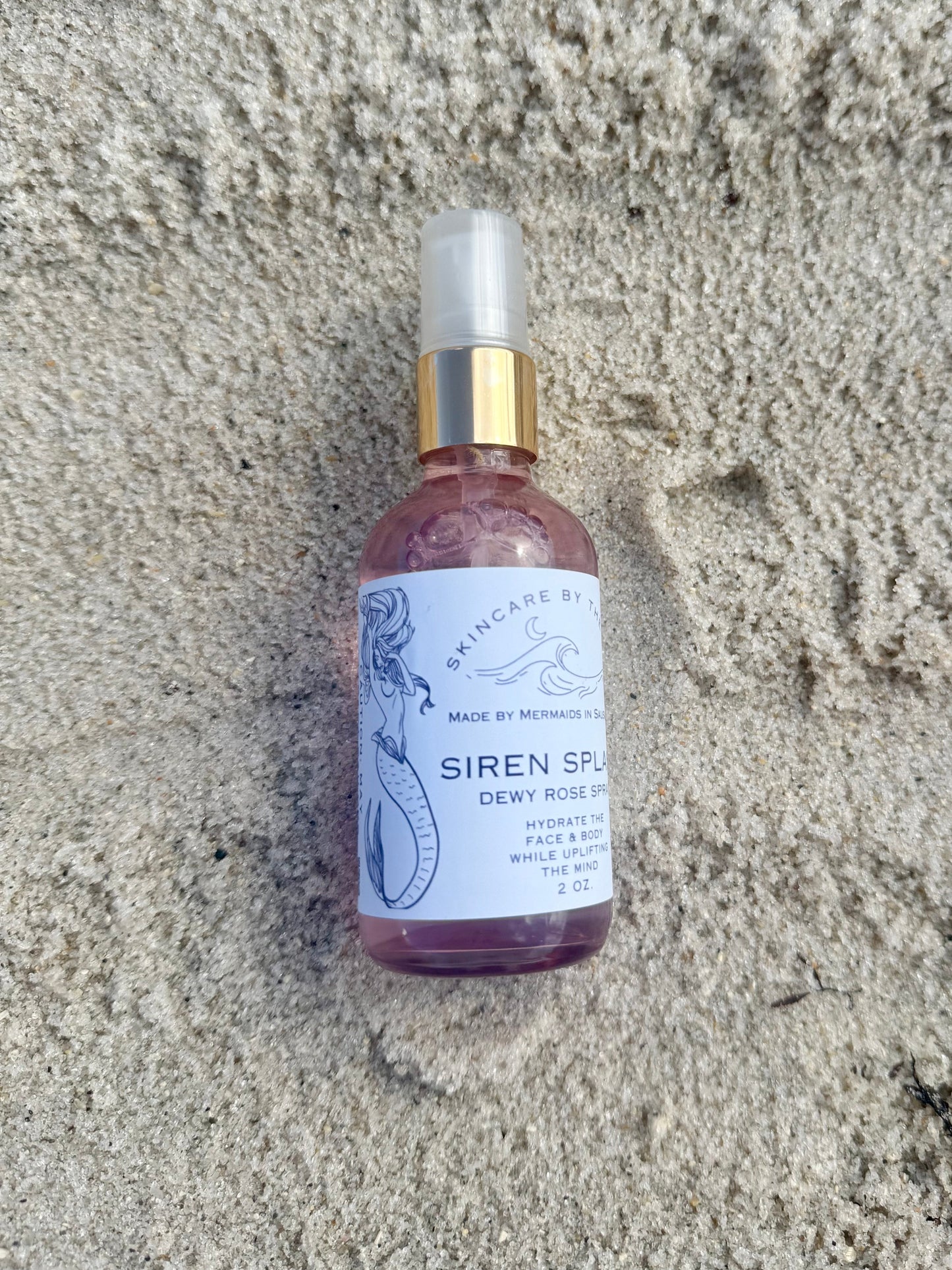 Makeup setting spray on sandy background