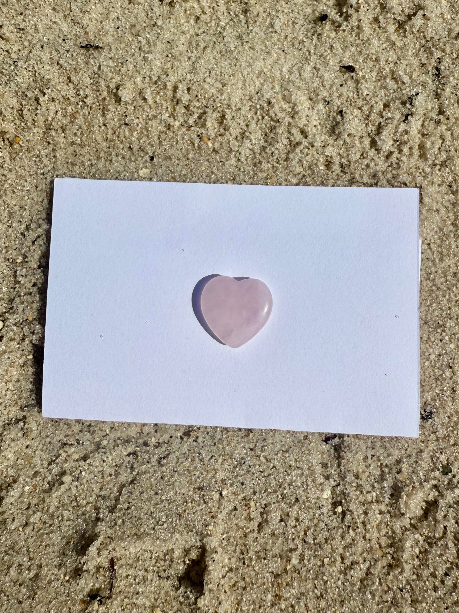 Rose Quartz Crystal Heart on the sand